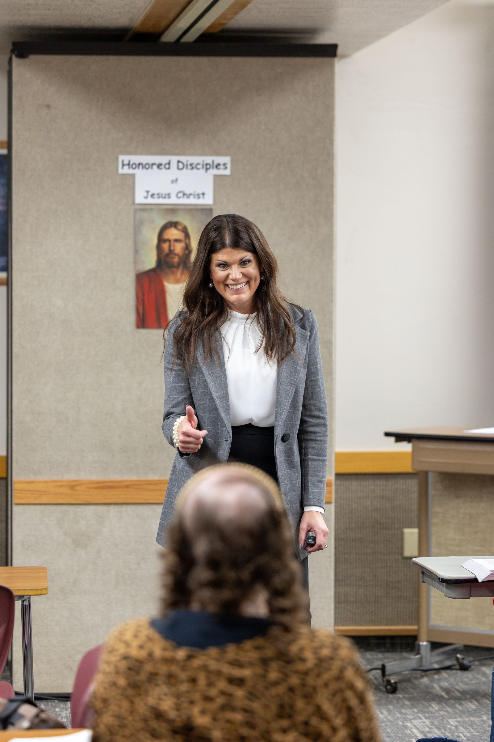 Female teacher smiling and giving her student a thumbs-up